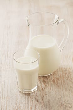 A Glass and a pitcher with milk