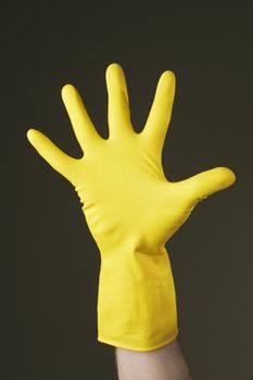 Hand with a protective yellow rubber glove