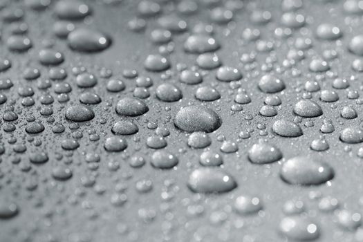 Droplets on a car. Short depth of field. The image may appear grainy, but it's caused by the metallic paint.