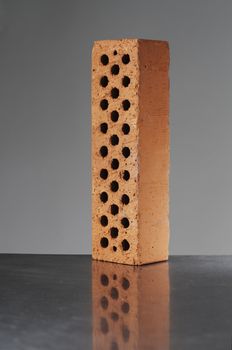 A perforated brick on reflecting metal surface