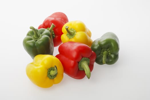Different colors of bell peppers on light gray surface