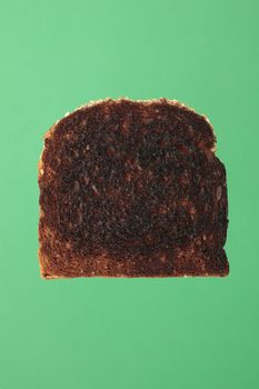 A Slice of burnt toast bread on green