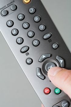 Digital television remote control, thumb pressing "ok" button