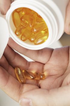 Omega 3 fish oil gel capsules on a hand