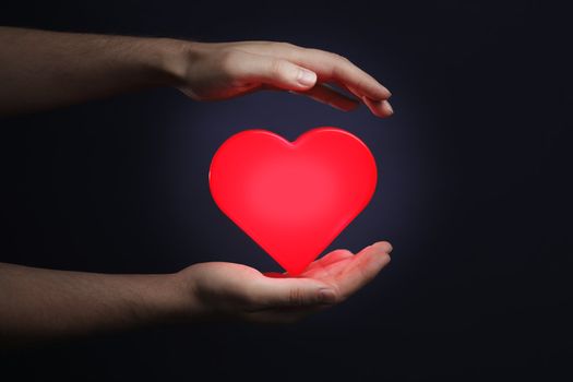 Man holding a red glowing heart in his hands