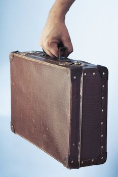 Hand carrying an old suitcase
