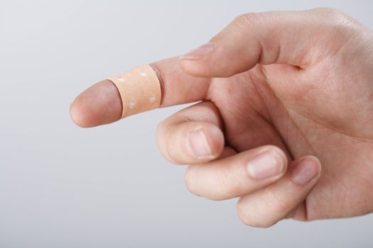 A finger with textile adhesive bandage. Short depth-of-field.