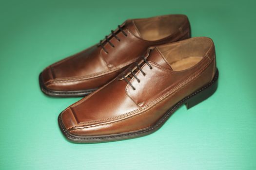 Men's brown leather dress shoes photographed with ring flash. Short depth of field.