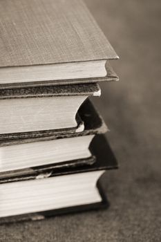 A Sepia toned image of a pile of old books