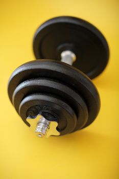 Iron dumbbell on yellow surface