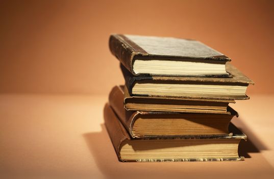 Stack of old books on brown background