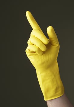 A Hand with yellow protective glove pointing with a finger
