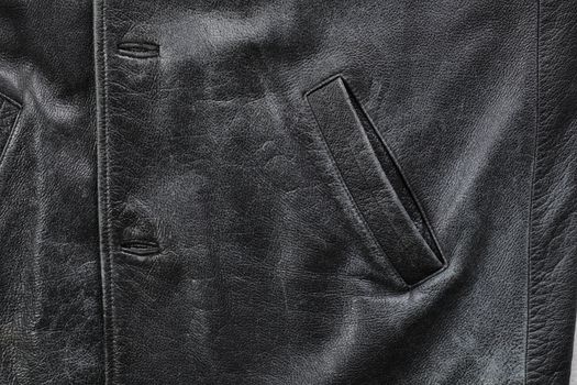 Pocket detail of an old black worn leather jacket