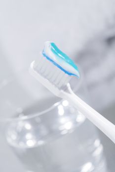 Toothbrush with some toothpaste and a glass of water