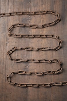 Old rusty chain on wooden background