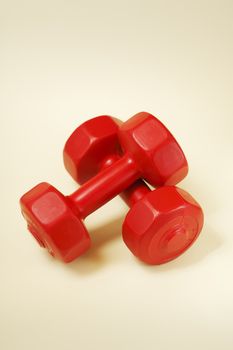 A pair of red small plastic dumbells