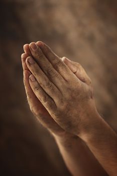 Dirty hands clasped together for a prayer