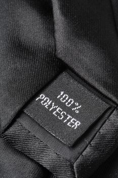 "100% polyester" label on a black tie