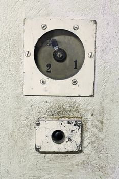 Old and dirty elevator button with a gauge