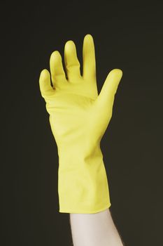 Hand with yellow protective rubber glove