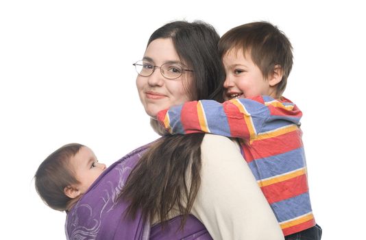 Woman carrying her little daughter in a sling. Her son hugging her from behind