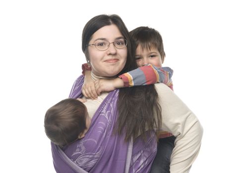 Woman carrying her little daughter in a sling. Her son hugging her from behind