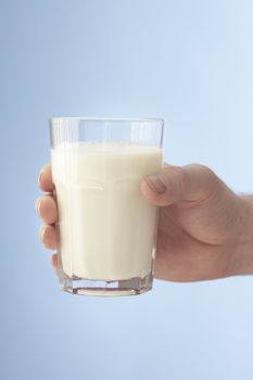 A Glass of milk held by a hand