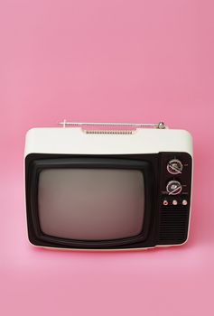 old 12 inch black and white portable television on pink surface