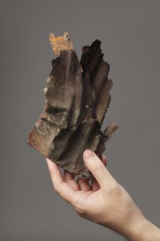 Man holding a rusty piece of metal in his hand