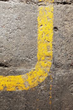 Yellow line on an old concrete floor makes a curve
