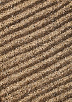 Lines in coarse sand, drawn by fingers.