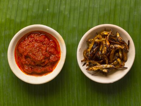 close up of bowls of fried anchovies and sambal chili