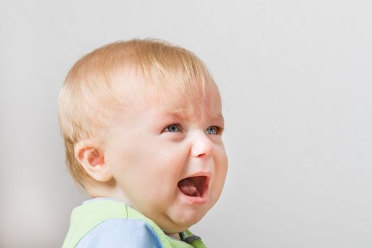 Crying boy around 7 months of age. Some space for your own text on the side