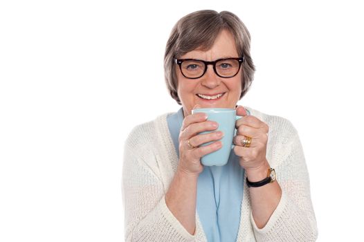 Smiling lady drinking hot coffee in front of camera