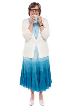 Full length shot of an old lady posing with a coffee mug