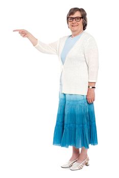 Full length portrait of an attractive woman indicating away