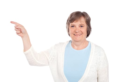 Matured casual lady pointing at copy space over white background