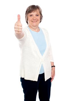 Smiling old lady showing thumbs up gesture to camera. Isolated on white