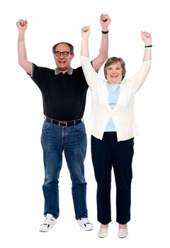 Excited aged couple posing with raised arms. All on white background
