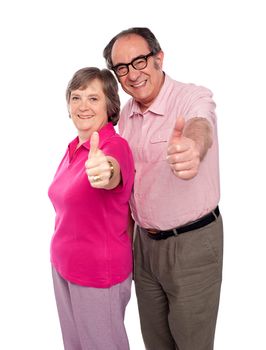 Senior couple gesturing thumbs up towards camera, isolated