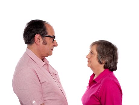 Beautiful aged couple looking into each others eyes isolated over white