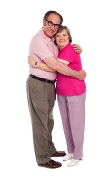 Happy aged woman hugging her husband and looking at camera