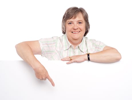 Closeup of an attractive old woman indicating towards billboard