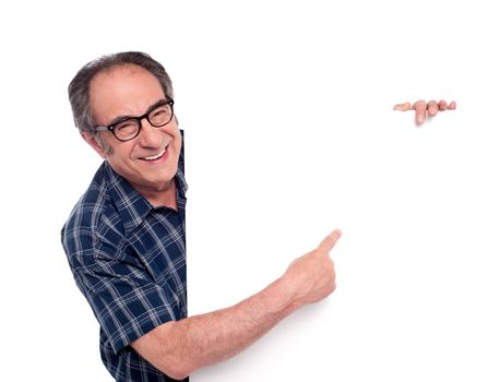 Man pointing at white blank poster and smiling. Wearing eyeglasses