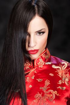 pretty woman in red Cheongsam on dark background