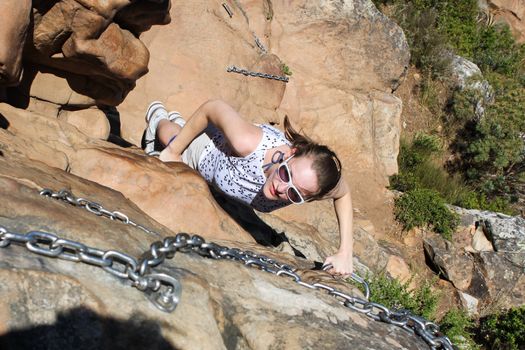 Woman climbing up lions head, cape town, south africa