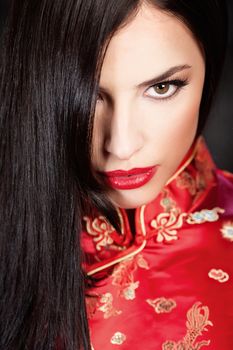 pretty woman in red Cheongsam on dark background