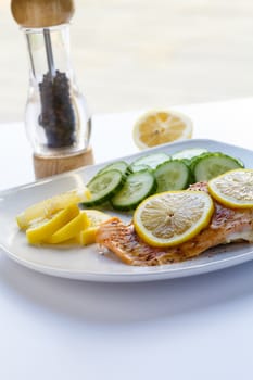 Baked salmon with lemon slices and cucumbers
