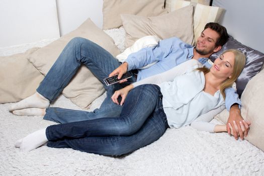 Young Couple lying On A Couch watching tv