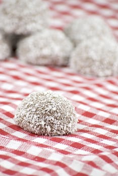 Chocolate and coconut covered marshmallow over red and white cloth